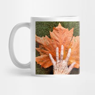 Autumn leaf and hand Mug